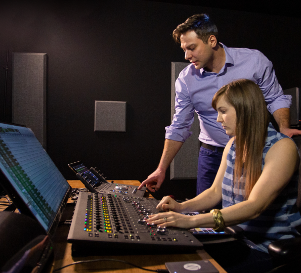 two humans mixing sound effects in a studio